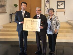 林大使から叙勲叙勲された肥田医師（中央）と文子（あやこ）夫人（提供写真）