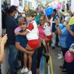 両親に抱かれてマナウス市の病院から退院する兄弟とそれを見送る人々（ Arthur Castro/Secom Governo do Amazonas）