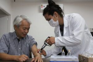 父親のエドアルドさんに吸い玉治療を施す中島悠理さん(右)