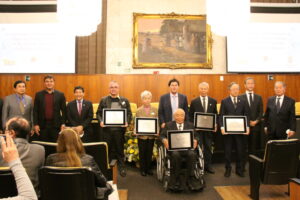 記念プレートを授与された５人（中央）と、式典に出席した関係者