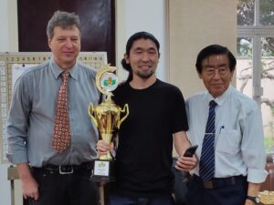 優勝トロフィーを受け取る浜公志郎さん（中央）とジェームス会長（左）と川合昭元会長（右）