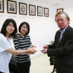 社会奉仕部の小松副部長と小田部長から寄付金を受け取る園田副会長（左から）