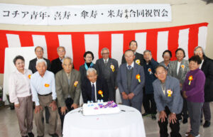祝賀会のケーキカット後の記念撮影におさまる祝賀該当者と来賓たち