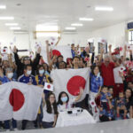 ブラジリア日本語モデル校の講堂で、日本チーム勝利の一瞬。中央で日の丸を広げているのが林大使（写真＝矢田さん提供）