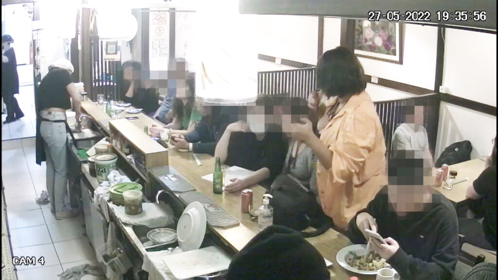 窃盗犯が立ち上がり際、隣席女性のカバンを肩に掛け、持ち去る瞬間を捉えた防犯カメラ映像