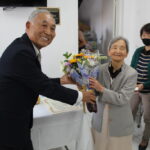 花束を受け取る掛橋さん（左は谷口会長）