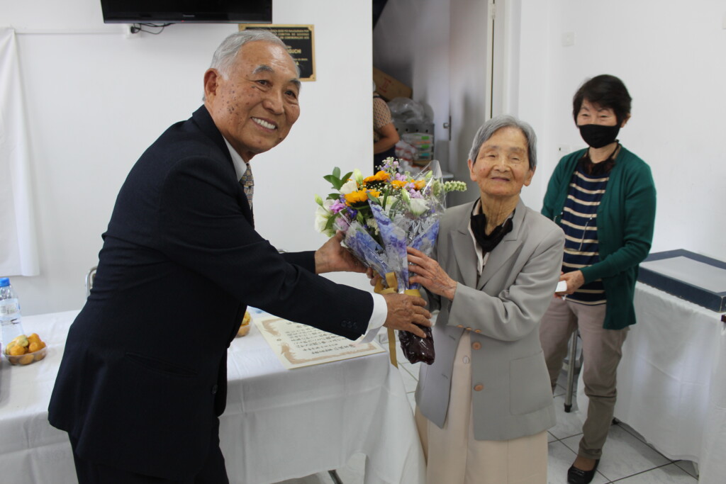 花束を受け取る掛橋さん（左は谷口会長）