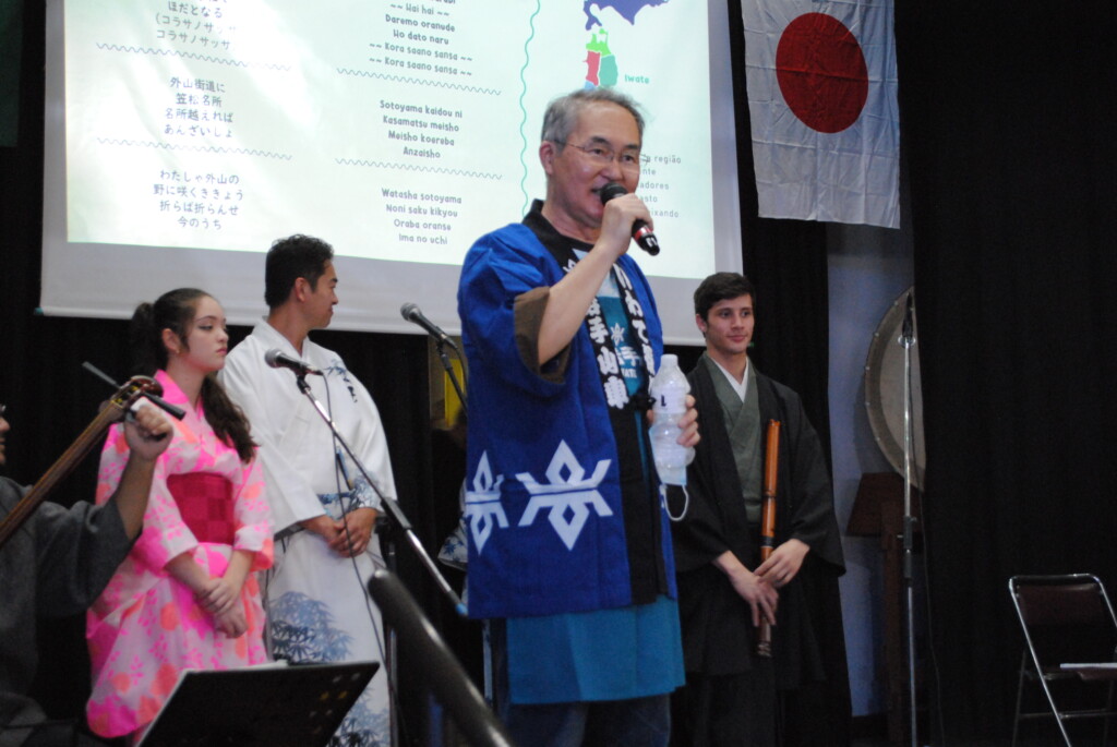 舞台上で挨拶をする岩手県人会多田マウロ会長