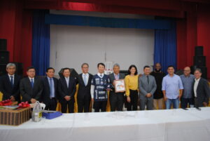 歓迎会での林大使（中央左）と墨絵を手に持つ津田理事長（中央右）