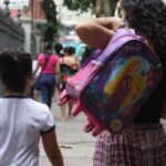 母親に伴われて学校に行く小学生（Tania Rego/Agencia Brasil）