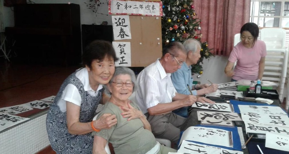 書道をする入居者らと潮さん（左後ろ）