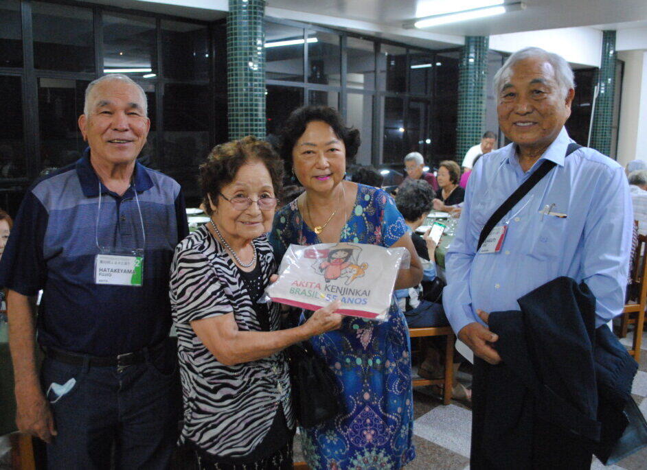 秋田県人会からの贈り物を受け取る杉本会長（左から２人目）