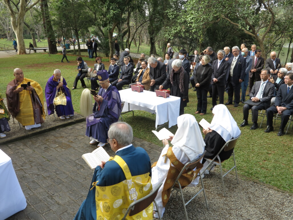 読経する僧侶らと焼香の列