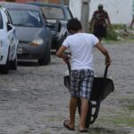 手押し車で何かを運ぶ少年（©Valter Campanato/Agencia Brasil）