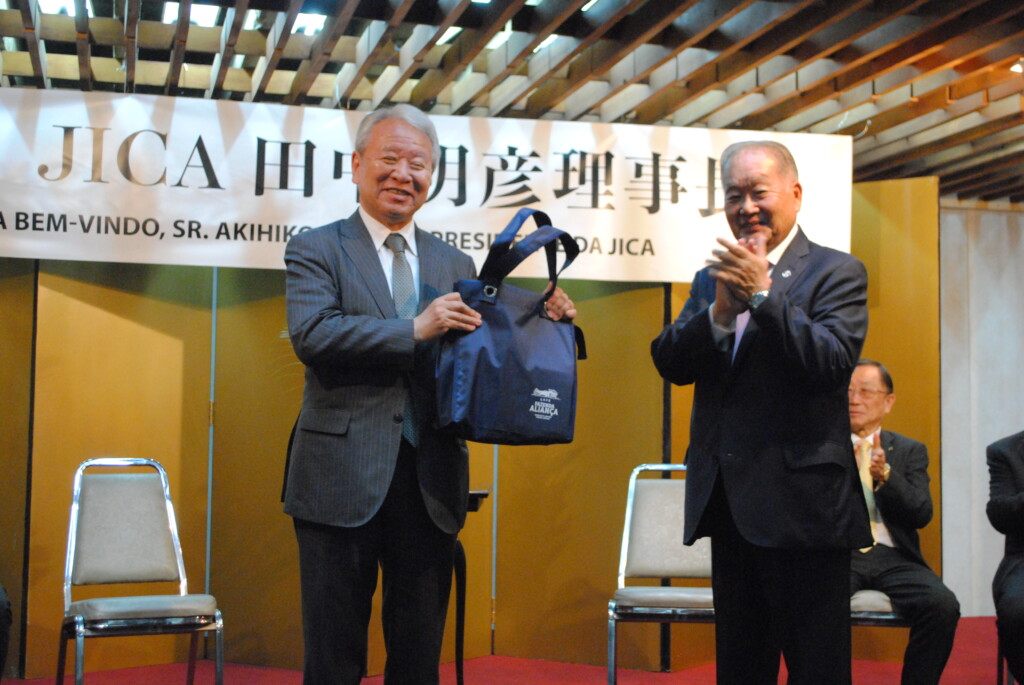 石川文協会長から田中理事長に歓迎品が手渡された