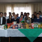寄贈された基礎食料品を前にした龍千多会関係者（提供写真）