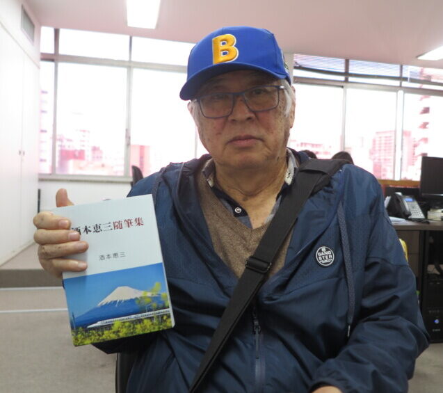 著作を手に持つ坂本さん
