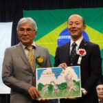 森繁親長崎県人会会長に紙芝居を贈呈する鈴木史朗長崎市長（右）