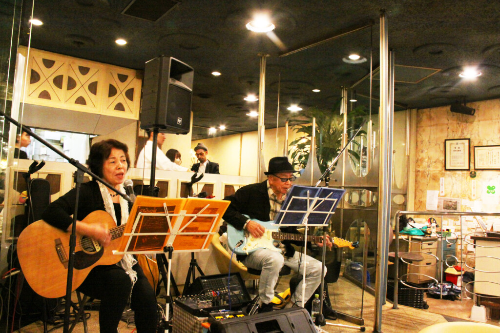 大阪市内の老舗喫茶店「マヅラ」で歌う「くるみの樹」の２人。左から、やまのはさん、国谷さん（１０月１０日撮影）
