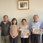 カレンダーと寄付金を受け取る各日系団体、山田会長と本郷さん（中央左）