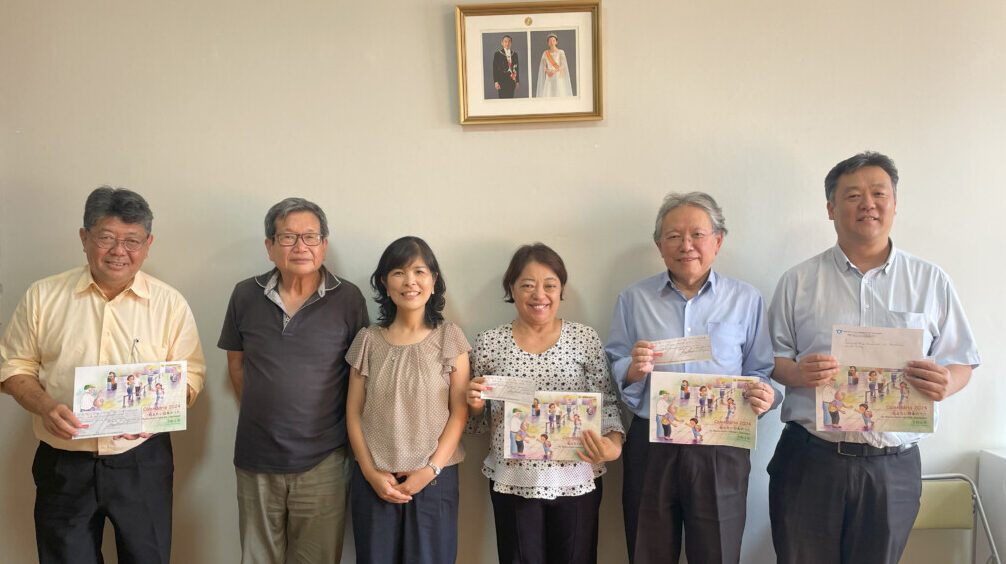 カレンダーと寄付金を受け取る各日系団体、山田会長と本郷さん（中央左）