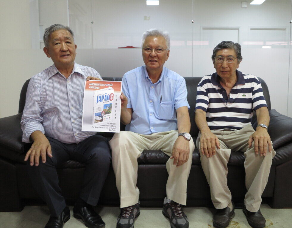 ポ語『日本の歴史・漫画』４版の写真を手に、左から鈴木清ジョージ元会長、阿久津パウロ会長、桂川トミオさん