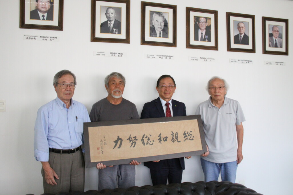 寄贈された渋沢栄一の揮毫。左から根塚さん、白石さん、税田会長、羽場さん