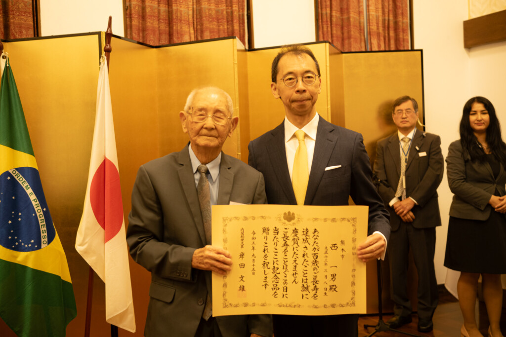 清水総領事から表彰状を受け取る西一男さん