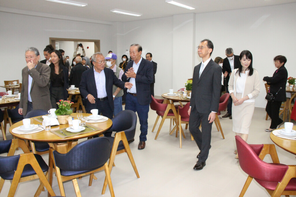 増設された食堂内で清水総領事夫妻（右側）を案内する援協役員