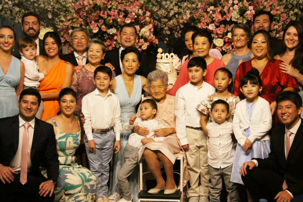 子孫に囲まれる金城敏子さん（中央）