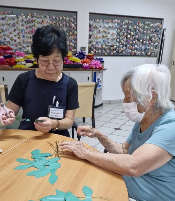 さち子さん（右）と一緒に３月のダリア祭りに向けて飾りを作っている様子