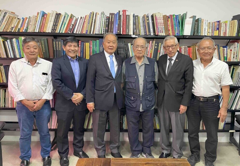 案内に編集部を訪れた上原ミルトン定雄上映会実行委員長、高良律正沖縄県人会会長、石川レナト文協会長、宮城あきら沖縄移民研究塾代表、西尾ロベルト文協副会長、島袋栄喜沖縄県人会元会長(左から)
