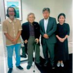 回顧展を訪れた佐野総領事（中央右）と記念写真を撮る豊田さん（中央左）