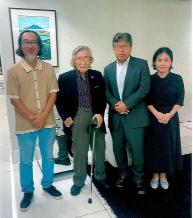 回顧展を訪れた佐野総領事（中央右）と記念写真を撮る豊田さん（中央左）