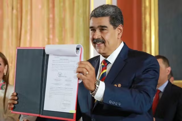 署名したばかりの法令をかざすマドゥーロ大統領（Governo da Venezuela）