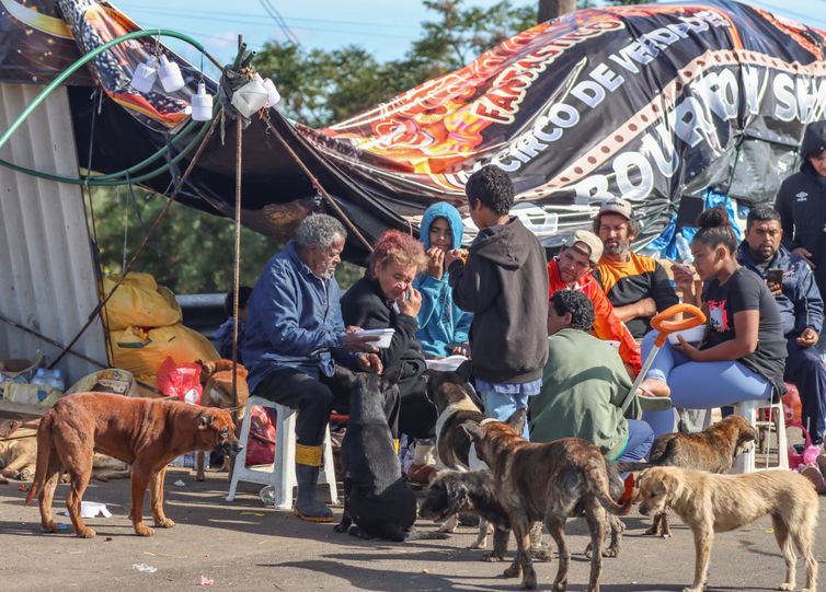 強盗被害が心配で高速道の脇でキャンプを張り、浸水家屋を見守る人達（© Rafa Neddermeyer/Agência Brasil）