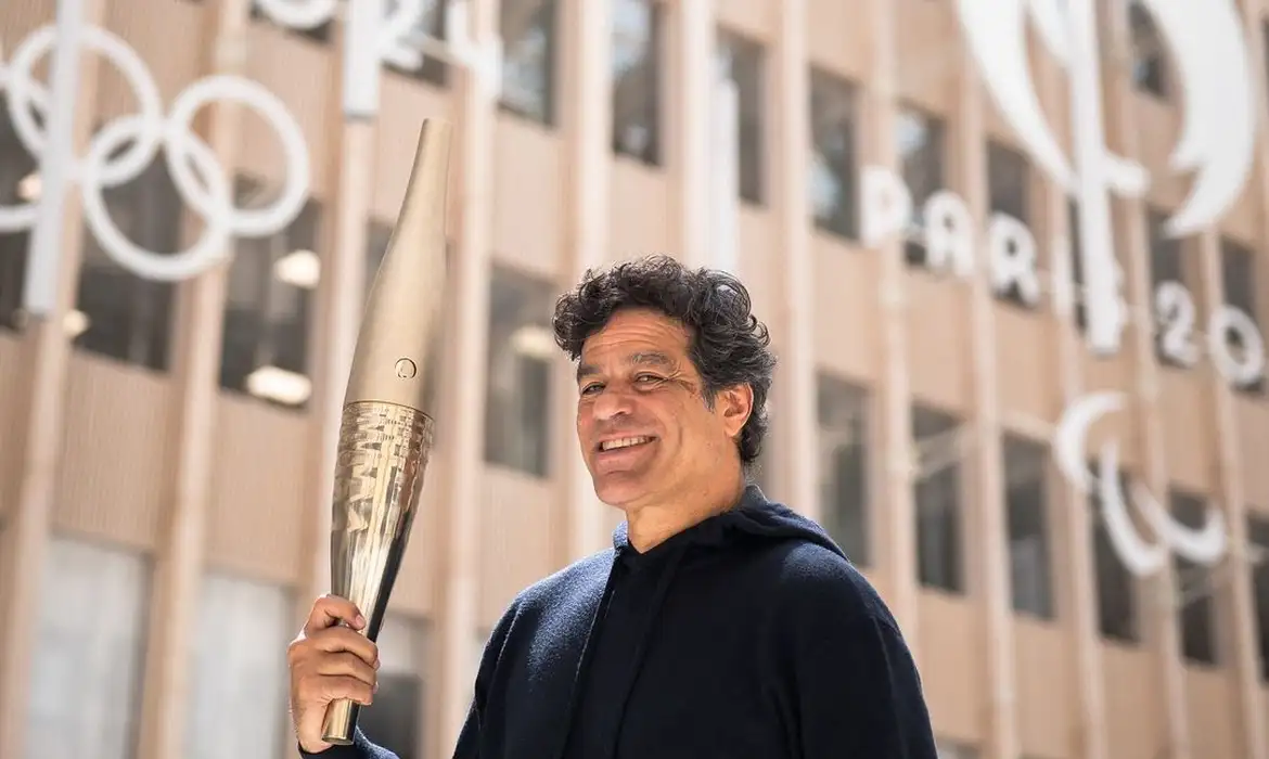 パリ五輪の聖火を手に、聖火ランナーに選ばれたことを発表したライー（©Reproducao Instagram/Paris 2024）