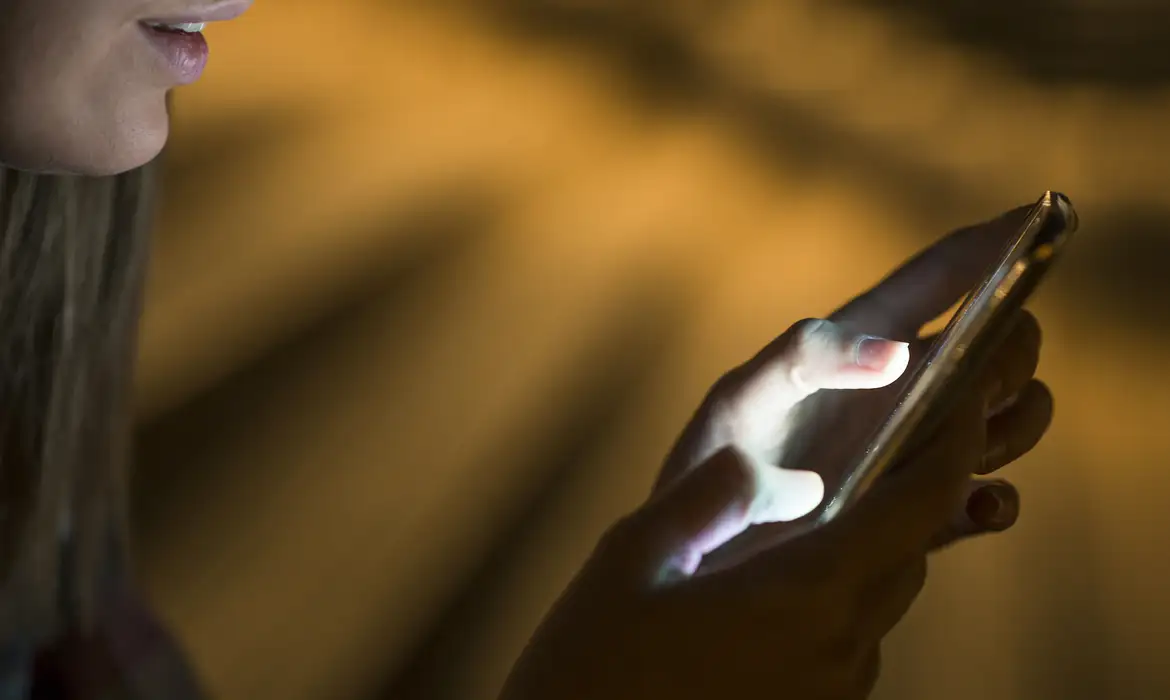 携帯電話を操作する顧客（©Dragana Gordic/Freepik）