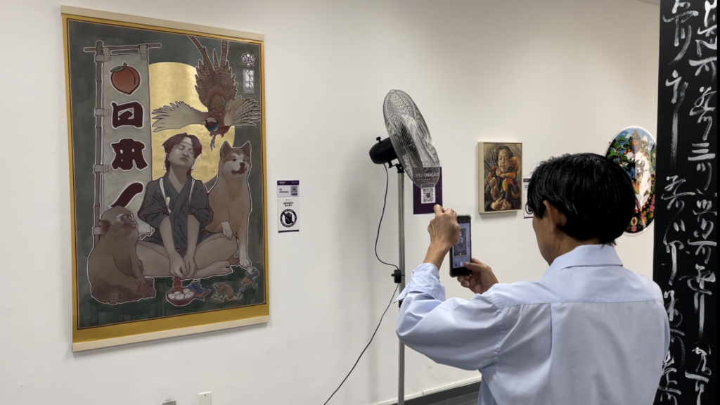 展示作品を撮影する来場者