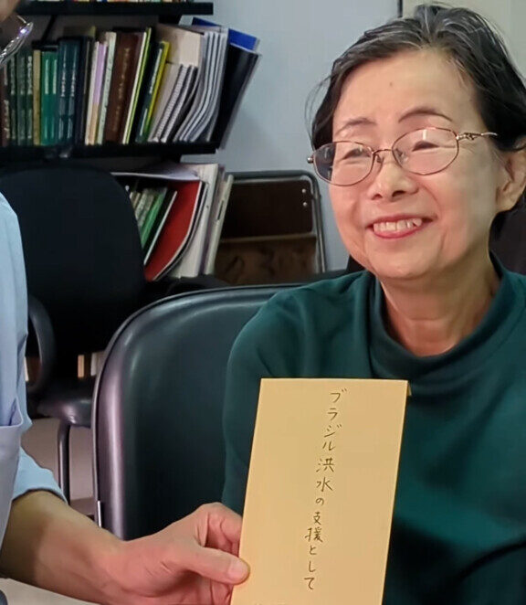 本部から預かった封筒を渡す橋本孝子さん
