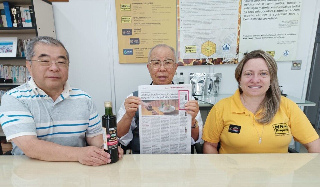 受賞記事を持つ松田会長（中央）と和田社長、アナ・パウラ・アモリン販売課長