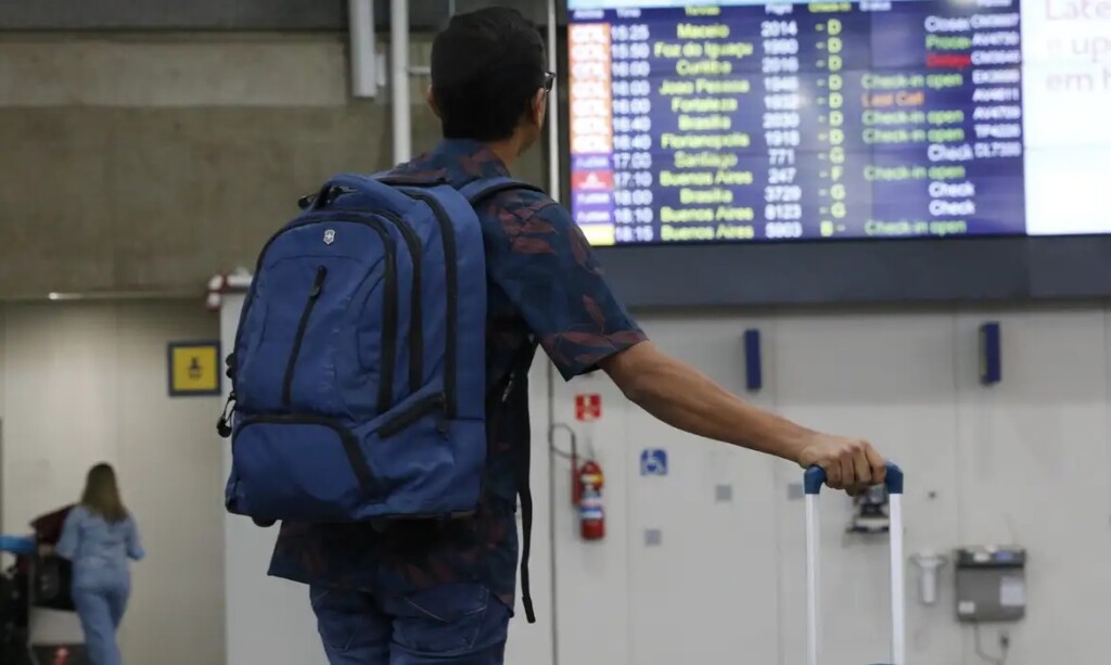 搭乗予定の便の情報を確認する旅行者（© Fernando Frazão/Agência Brasil）