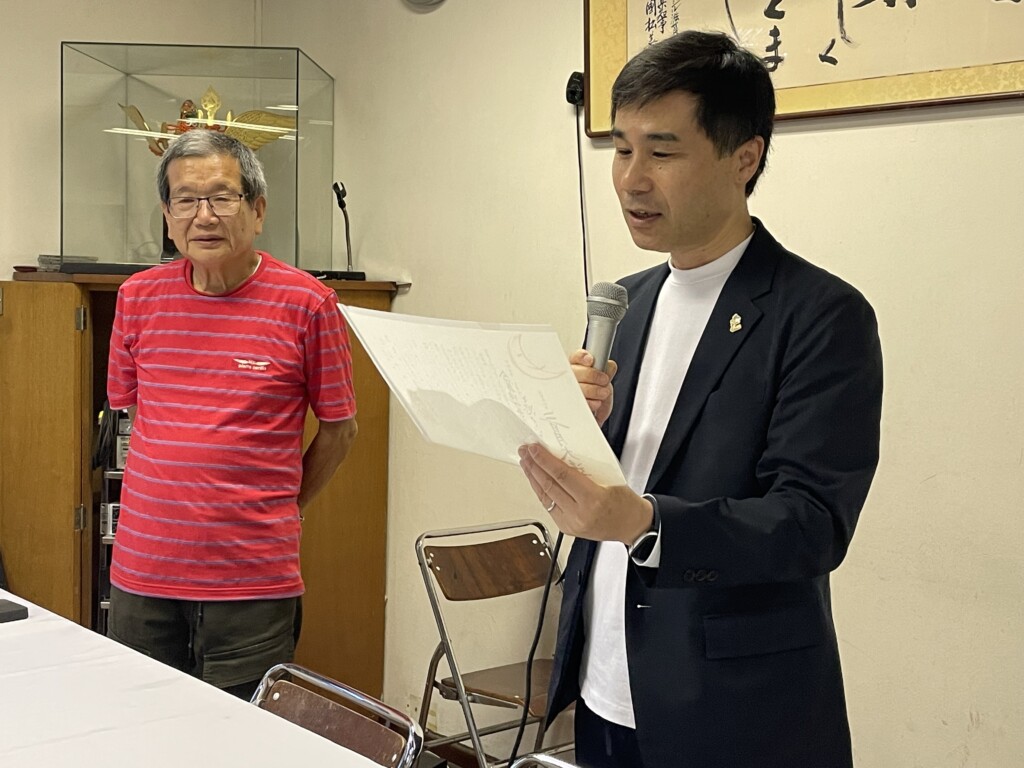 三日月知事からの親書を読み上げる萩野国際課長