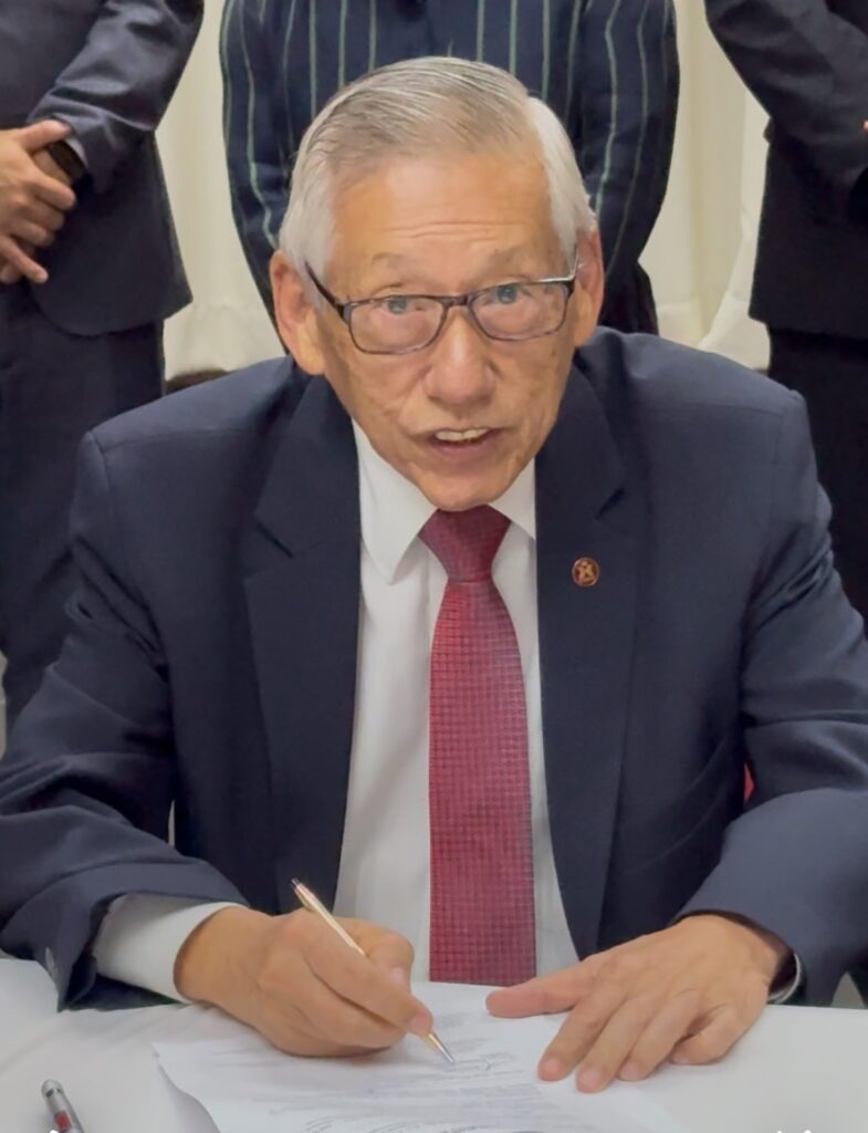 就任証書にサインをする西尾新会長