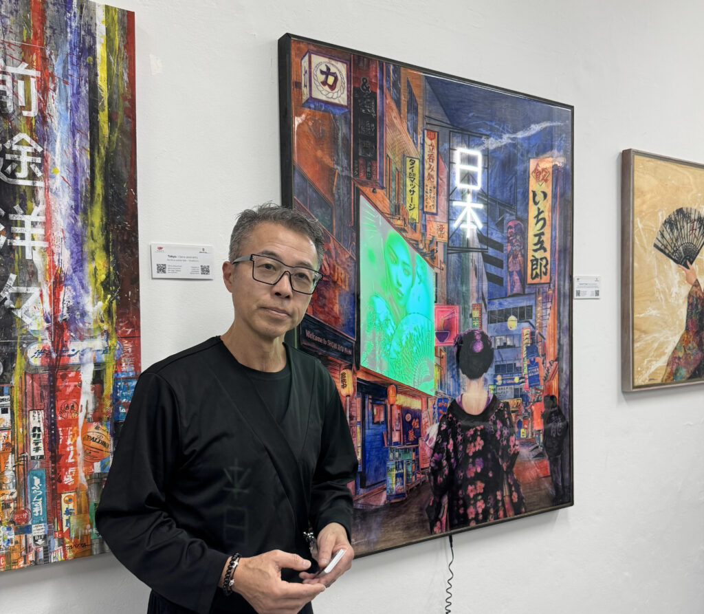 東京の夜景をテーマにした作品の横に立つ滝田クラウジオさん