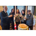 鏡開きの後に祝いの乾杯を行うルシアさん（中央）