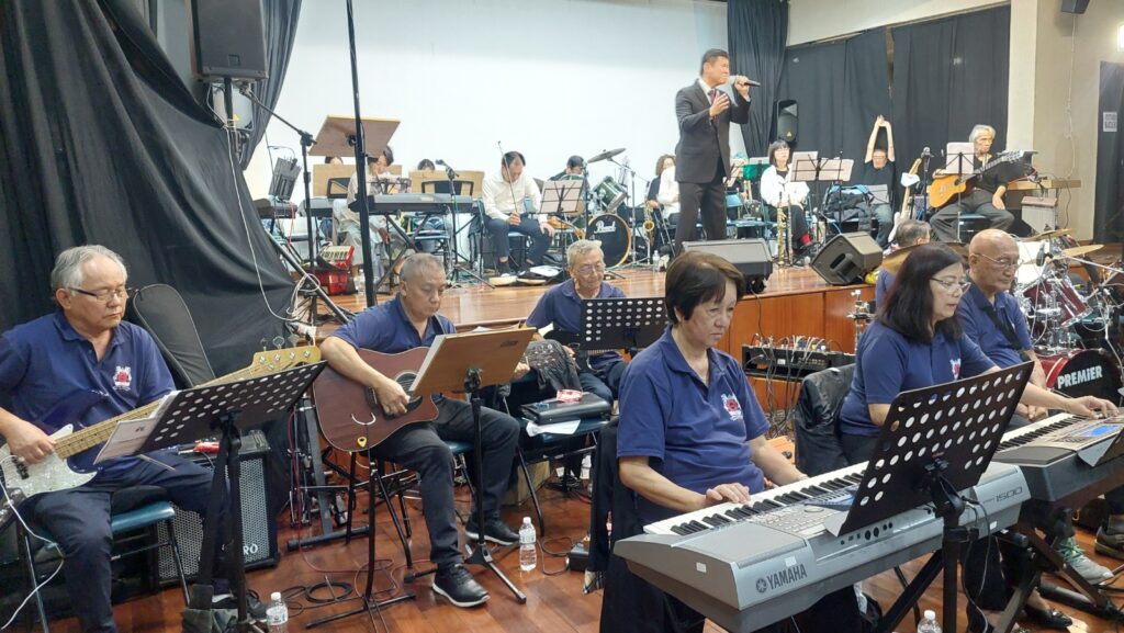 楽団の演奏で歌う歌手（ゴールドＡの久保田レオナルド氏とコスモス楽団）(©Silvio Sano）