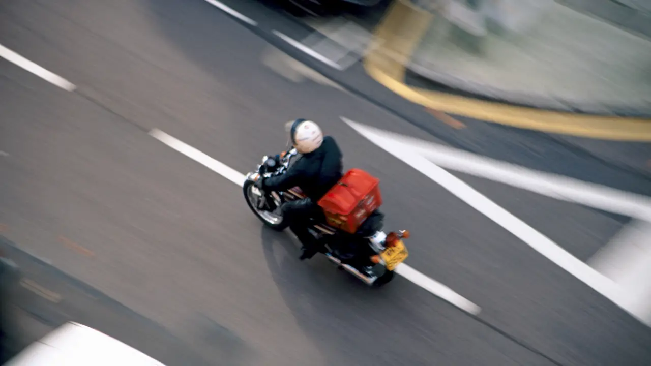 デリバリー事業に不可欠なバイクでの配送風景（Andrew Holt/Getty Images)