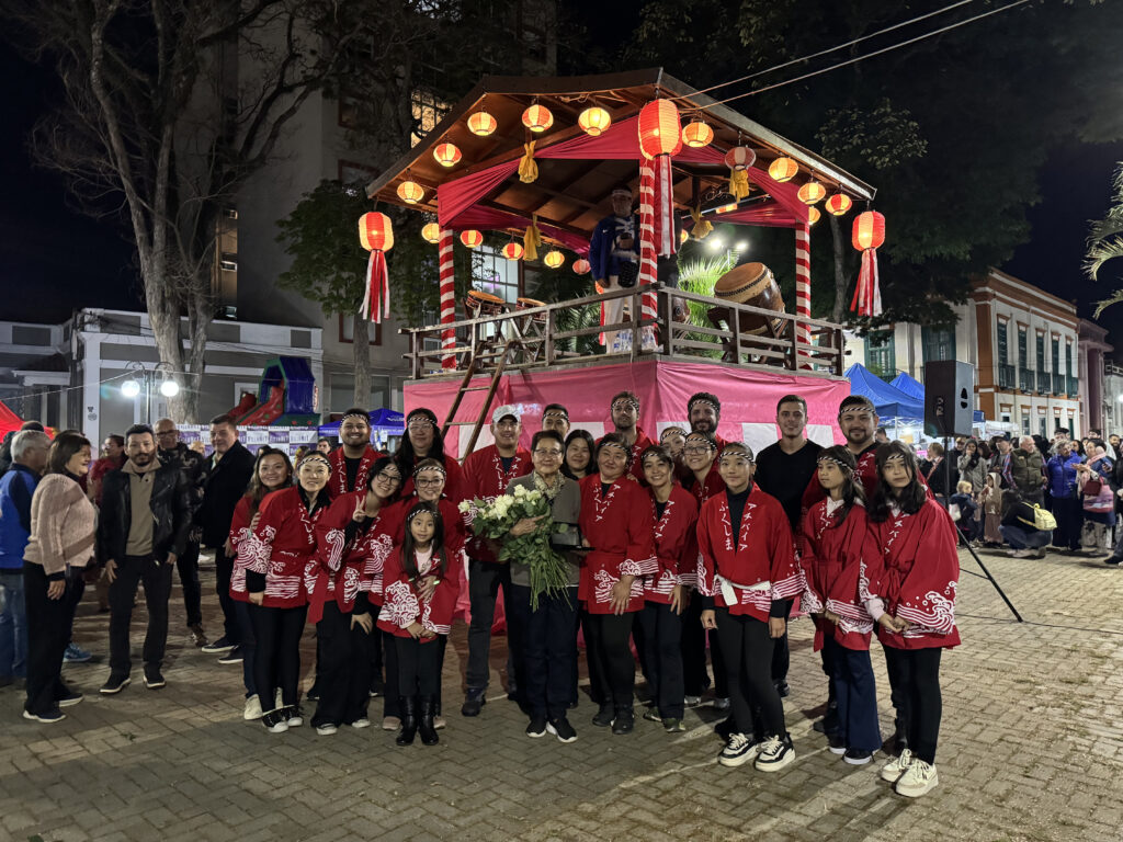 アチバイア福島県人会の皆さんから花を受け取った富江さん（中央）